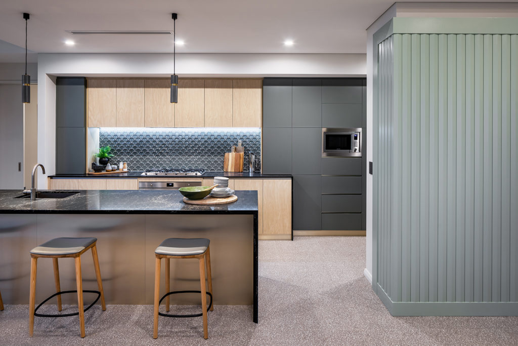 Art deco styled kitchen with green fan shaped tiles on the splashback